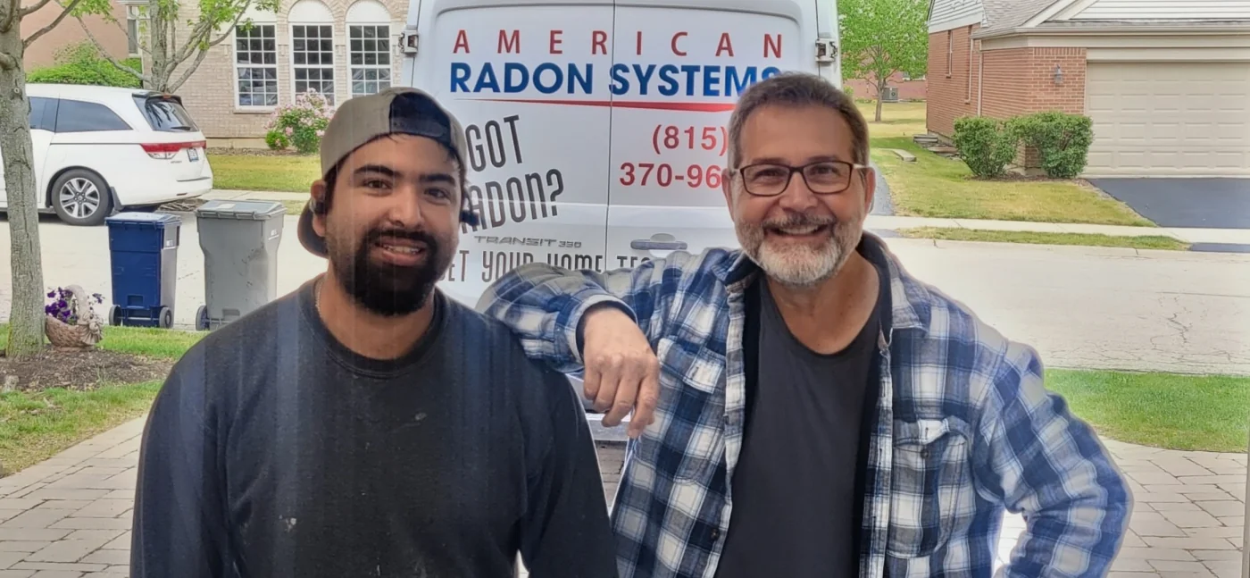 Jose from American Radon Systems standing with a local celebrity in front of the ARS service van after a job.